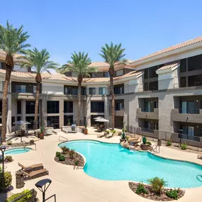 Pool and waterfall with gas grilling stations and dining areas