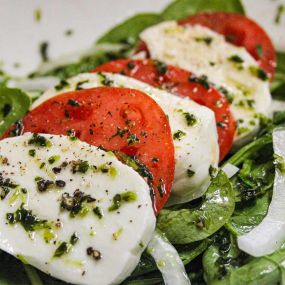 Salade Caprese
Sliced buffalo mozzarella, beefsteak tomatoes & bermuda onions with a fresh avocado oil dressing, on a bed of spinach.