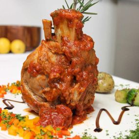 Porc Osso Bucco
Slow-roasted pork with plum tomato ragu, fennel and Bermuda onion with truffle herb roasted potatoes & sautéed vegetables.