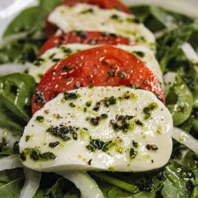 Salade Caprese
Sliced buffalo mozzarella, beefsteak tomatoes & bermuda onions with a fresh avocado oil dressing on a bed of spinach