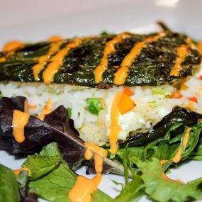 Piment Poblano Farci
Grilled poblano pepper stuffed with goat cheese &vegetable jasmine rice, topped with a spicy aioli and served on a bed of baby spinach with a side of sautéed vegetables.