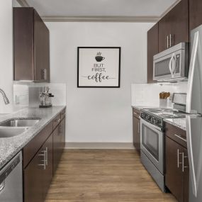 Kitchen with granite countertops, hardwood-style flooring, and dark wood cabinets.