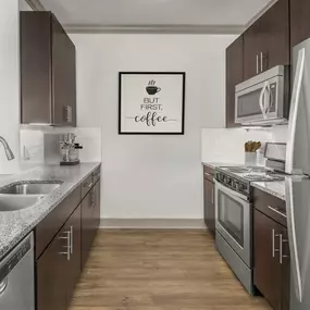 Kitchen with granite countertops, hardwood-style flooring, and dark wood cabinets.