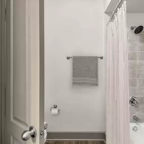 Bathroom with linen closet and bathtub and shower combination with tile surround