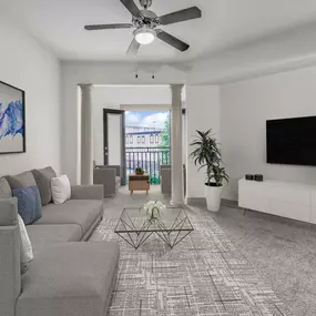 Living room with ceiling fan, carpet, and extra space with columns and Juliette balcony.