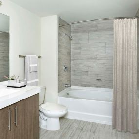 Bathroom with bathtub with tile surround and curved shower rod