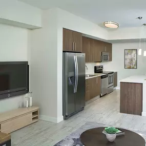 Open concept living and kitchen with wood look flooring and pendant lighting