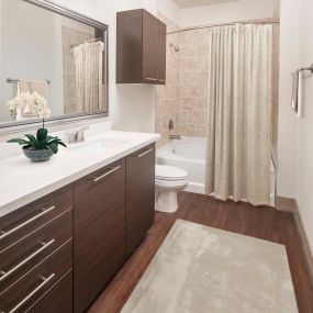 Bathroom with white countertops, a large soaking bathtub and stand up shower