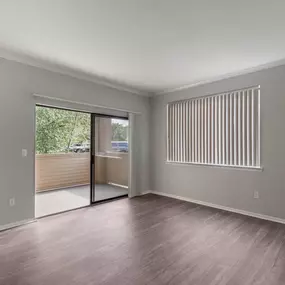 The unfurnished living room at Cierra Crest Apartments offers a blank canvas with access to a private balcony.