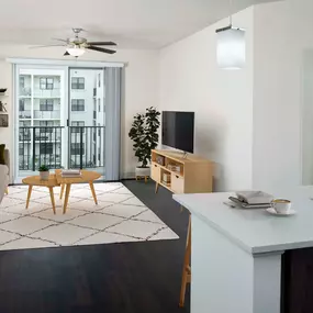 Living room with lighted LED ceiling fan and balcony at Camden Boca Raton apartments in Boca Raton, Florida.