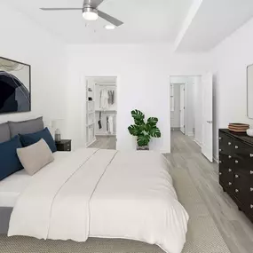 White contemporary apartment bedroom with walk-in closet and hardwood-style flooring throughout in Charlotte, NC