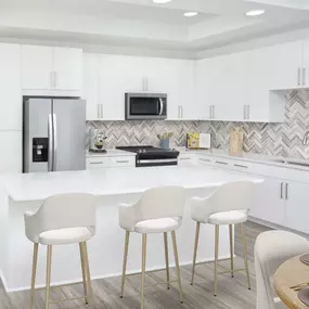 White contemporary apartment bedroom with herringbone backsplash, white cabinetry, and stainless steel appliances at Camden Grandview in Charlotte, NC