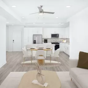 White contemporary apartment living room, kitchen, and dining area with hardwood-style flooring at Camden Grandview in Charlotte, NC