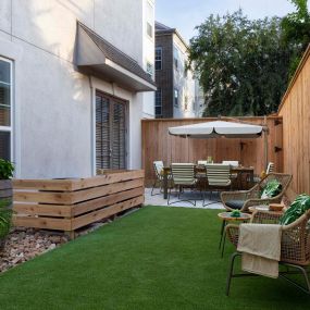 The townhomes private side yard with turf, dining, and seating areas