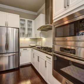 The townhomes kitchen with gas cooktops, stainless steel appliances, and wood flooring