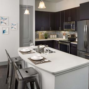 The terrace kitchen with quartz countertops stainless steel appliances and wood look floor