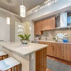 The Gallery kitchen with white quartz countertops, islands with bar seating, glass cooktops, and subway tile backsplash