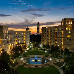 Exterior of building at night with water fountain courtyard