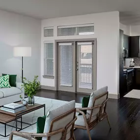 The Terrace living room alongside kitchen with wood flooring, espresso cabinetry, white quartz countertops, and access to a private balcony