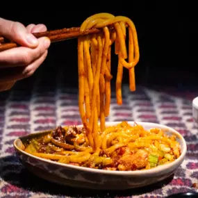 Volcano Rice Noodles served in a white round plate, featuring vibrant colors and spicy aromas, at Karamay, London