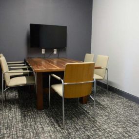 Private business center with TV and conference table.