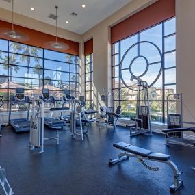 Well-lit fitness center with cardio and strength training equipment