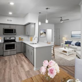 Open-concept dining and living area near contemporary kitchen with stainless steel appliances