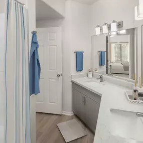 Camden Pecos Ranch Apartment home Chandler Arizona spacious bathroom with wood-like flooring dual vanity sinks and shower tub combo with curved shower rod and tile surrounds