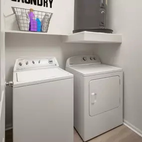 Camden Pecos Ranch Apartment home Chandler Arizona laundry room with full size side by side washer and dryer and a storage shelf and wood-like flooring