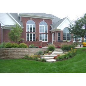 A large brick home with a beautiful lawn
