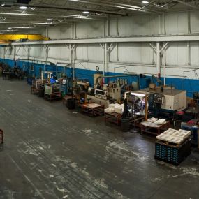 Interior view of sturdy grinding warehouse with forklifts.