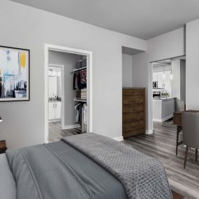 Contemporary midrise apartment bedroom with walk in closet and hardwood style floors