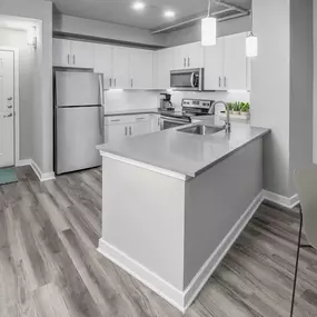 Contemporary midrise apartment kitchen with granite countertops and pendant lighting