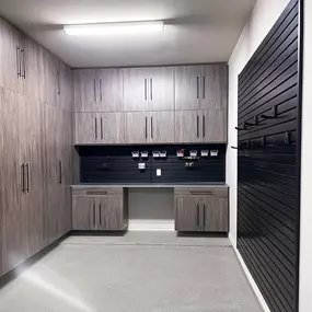Small Garage, Big Impact  This custom garage proves that limited space doesn’t have to mean limited function. Designed with high-performance epoxy flooring, full-wall custom cabinetry in a sleek textured finish, a built-in workbench, and slatwall organization systems, every inch is optimized to work