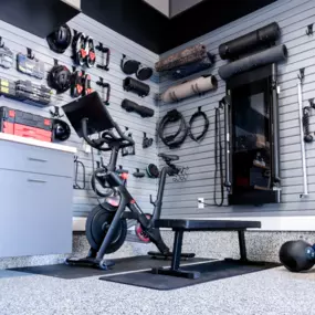 Custom Garage Gym with Epoxy Floor & Slatwall Organization – Southern Maine  Turn your garage into the ultimate home fitness zone. This custom garage gym features a durable, low-maintenance epoxy garage floor, premium slatwall organization system, and integrated wall-mounted fitness storage—perfect