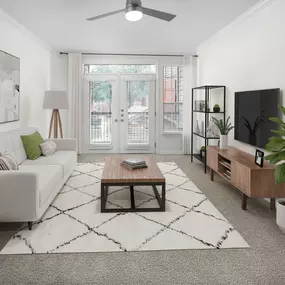 Renovated living room with carpet, modern ceiling fan, and private balcony at Camden Addison apartments in Addison, TX