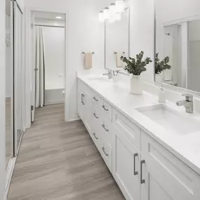 Bathroom with double vanity white quartz countertops and white shaker cabinets at Camden Addison apartments in Addison, TX