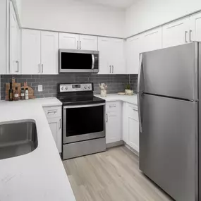 Kitchen with white quartz countertops and white shaker cabinets at Camden Addison apartments in Addison, TX