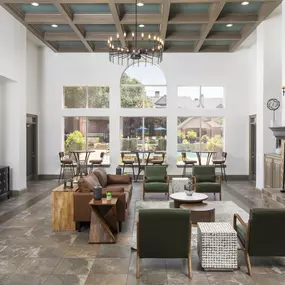 Resident lounge with seating and cozy fireplace overlooking the pool at Camden Addison apartments in Addison, TX