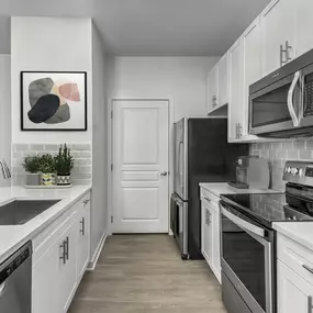 Kitchen with stainless steel appliances and gray subway backsplash