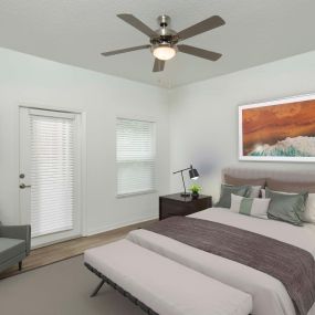 Bedroom with patio access wood look flooring and ceiling fan