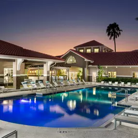 Resort style swimming pool at night alongside 24 hour fitness center