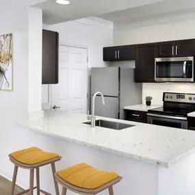 Kitchen with quartz countertops stainless steel appliances glass cooktop and undermount sink