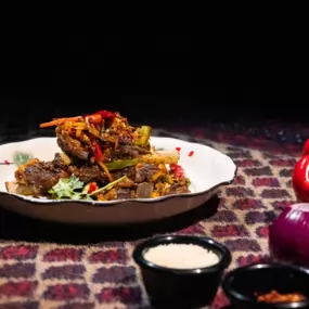 Crispy Lamb Chops in a white round plate on the table at Karamay, London.