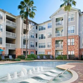 Resort-style swimming pool with Sun Loungers and Tanning Decks at Camden Heights Apartments in Houston, TX