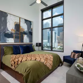 Warm modern finishes bedroom with views of downtown