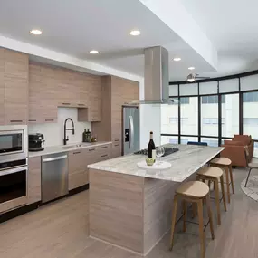 Warm modern finishes in kitchen with gas range quartz countertops and vent hood