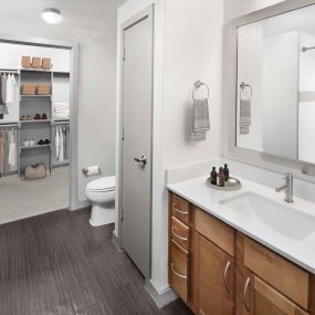 Bathroom with white quartz countertops and walk-in closet