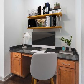 Built-in desk with cabinets and black granite countertop at Camden Design District