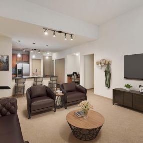Open concept living with high ceilings track lighting and carpet flooring